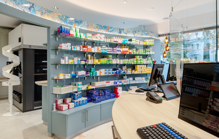 Moderne und frisch renovierte Innenansicht der Rotenbühl Apotheke mit einer stilvollen, geschwungenen Theke, hellen LED-Beleuchtungen und einem gut sortierten Medikamentenangebot.